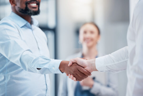 Shot of two unrecognizable businesspeople shaking hands in an office at work.